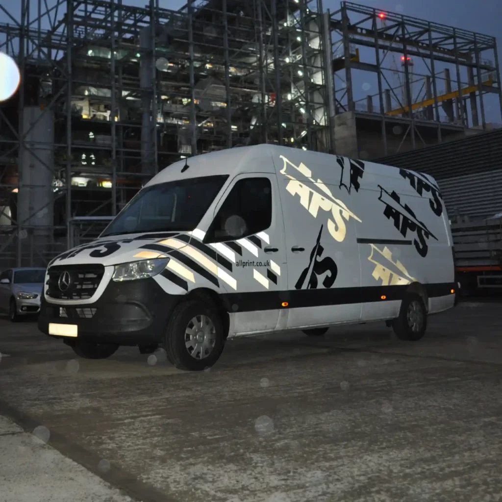 ORALITE 5200 Economy Series reflective sign vinyl applied to a delivery van as decorative cut-vinyl decals, pictured outside in the dark at night and the camera flash picking out the reflectivity of the decal shapes.