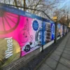 NU-COAT P12-H-P high grab polymeric print vinyl printed with educational display graphics that are informative and decorative, applied to hoardings that surround the exterior of a school fence.