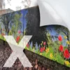 NU-COAT P12-P-X polymeric self-adhesive bubble-free graphics vinyl is mounted onto display boards fixed to an exterior wall, featuring a printed image of a wide angle photograph of a peaceful field of red poppies and yellow daffodils with dark green trees in the background.
