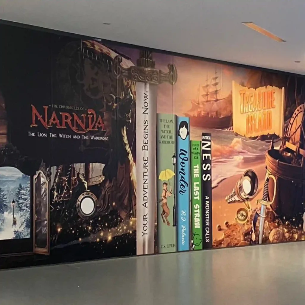 P16-P polymeric print vinyl features a permanent self-adhesive and has been printed with book-club graphics featuring imagery of giant books and their covers sitting on a shelf and applied as decorative wall graphics within a school corridor.