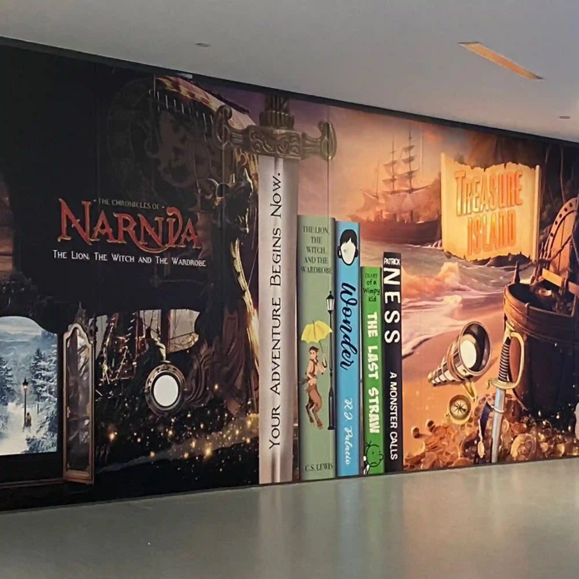 P16-P polymeric print vinyl features a permanent self-adhesive and has been printed with book-club graphics featuring imagery of giant books and their covers sitting on a shelf and applied as decorative wall graphics within a school corridor.