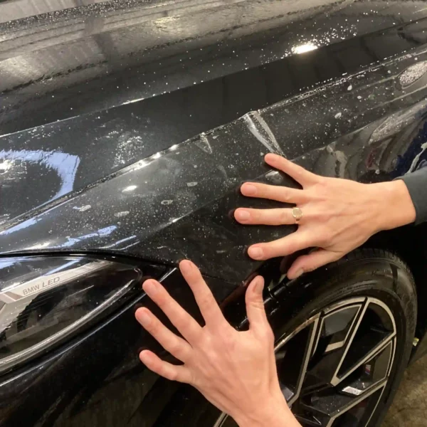 SLiding PPF into position on a car using a wet application process with a 'slide solution' of water and baby shampoo.