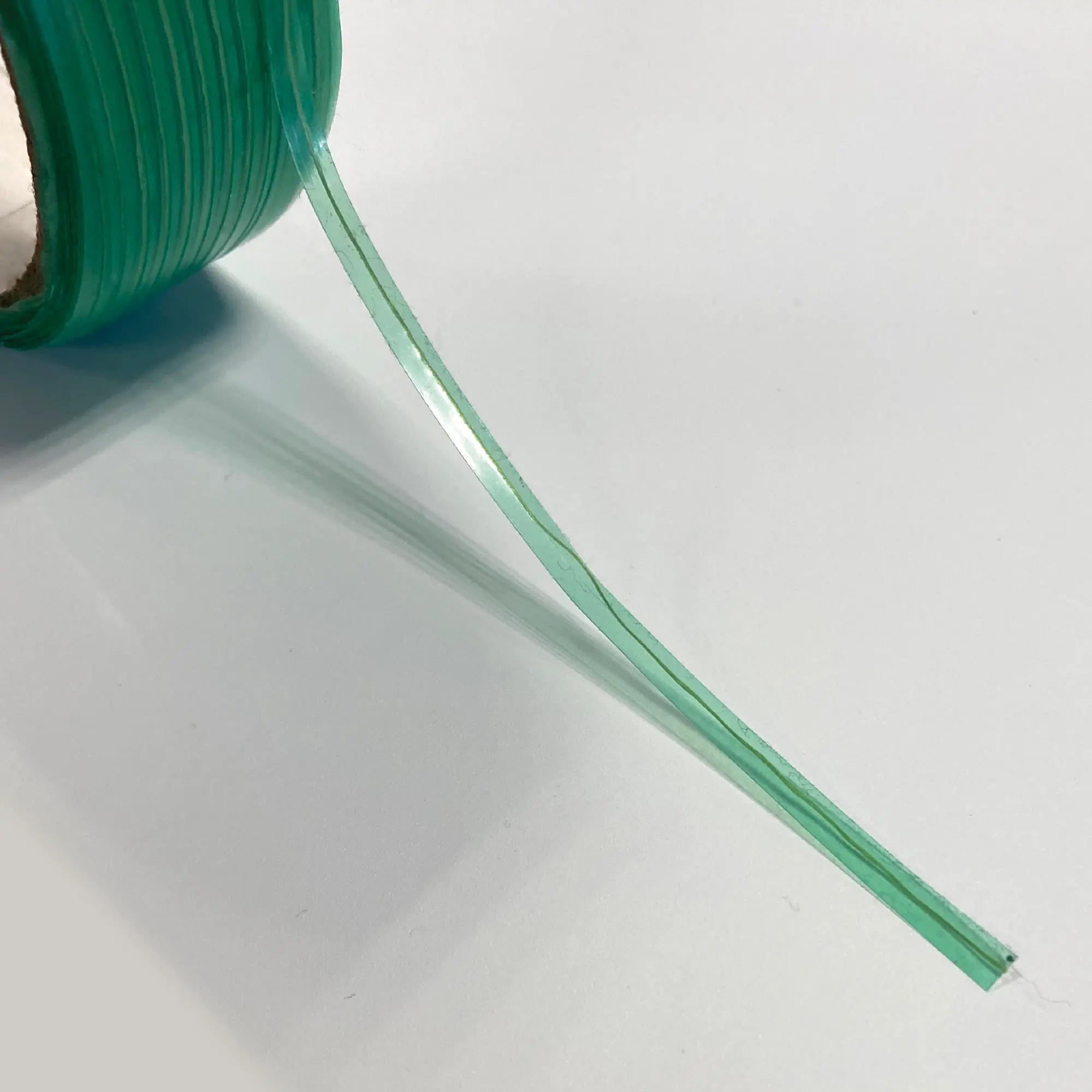 PRO-CUT vinyl wrapping knifeless tape in close-up detail to show the fine filament cutting edge and the translucent green coloured self-adhesive tape that surrounds the inner cutting wire.