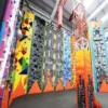 Floortex FV8-85 floor laminate is shown used to add slip-resistance and protection on a colourfully printed set of climbing wall graphics. The photo shows a wide view of all the different surfaces for climbers.