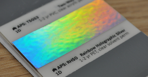 RH50 rainbow holographic silver swatch sample is pictured refklecting the full colour spectrum from it's holographic effect silver surface.