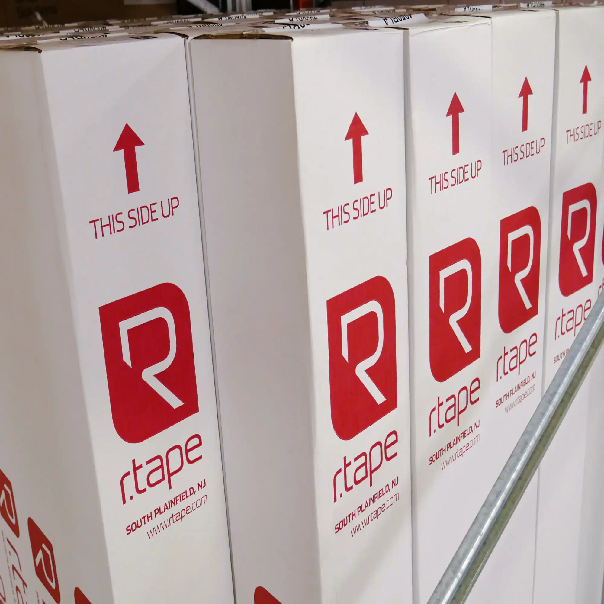 RTape application tapes are shown here all stacked next to each other in the All Print Supplies warehouse, with their distinctive bright red printed brand on the white carboard packaging.