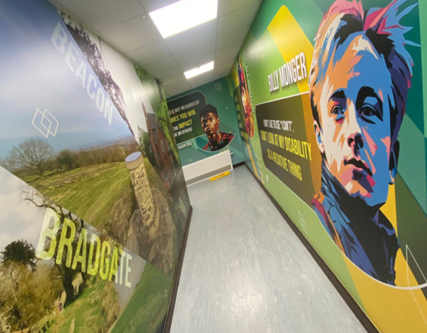 Looking down a long school corridor with educational and inspirational printed wallpaper graphics.