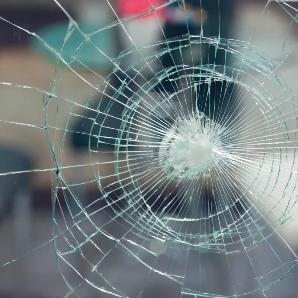 Avery SF 8 i Bomb Blast safety glass laminate vinyl with a spider web pattern scar that is typical of the shatter-proofing properties provided by this self-adhesive glazing laminate, holding the glazing together after blast impact or vandalism.