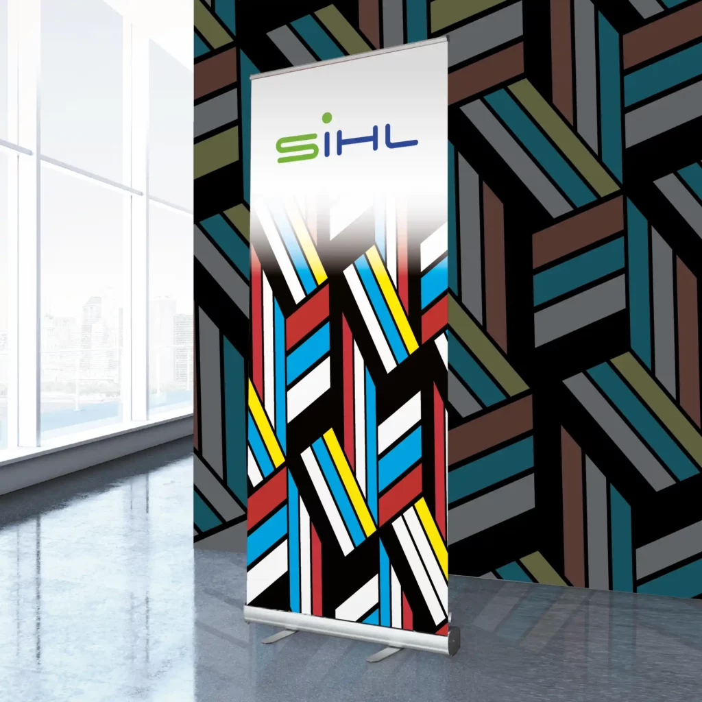 Sihl 3629 roll-up display print media, printed with All Print Supplies image sample graphics of colourful and bright striped geometric box patterns and the Sihl logo at the top of the banner, with matching, complimentary wall graphic images in the background.