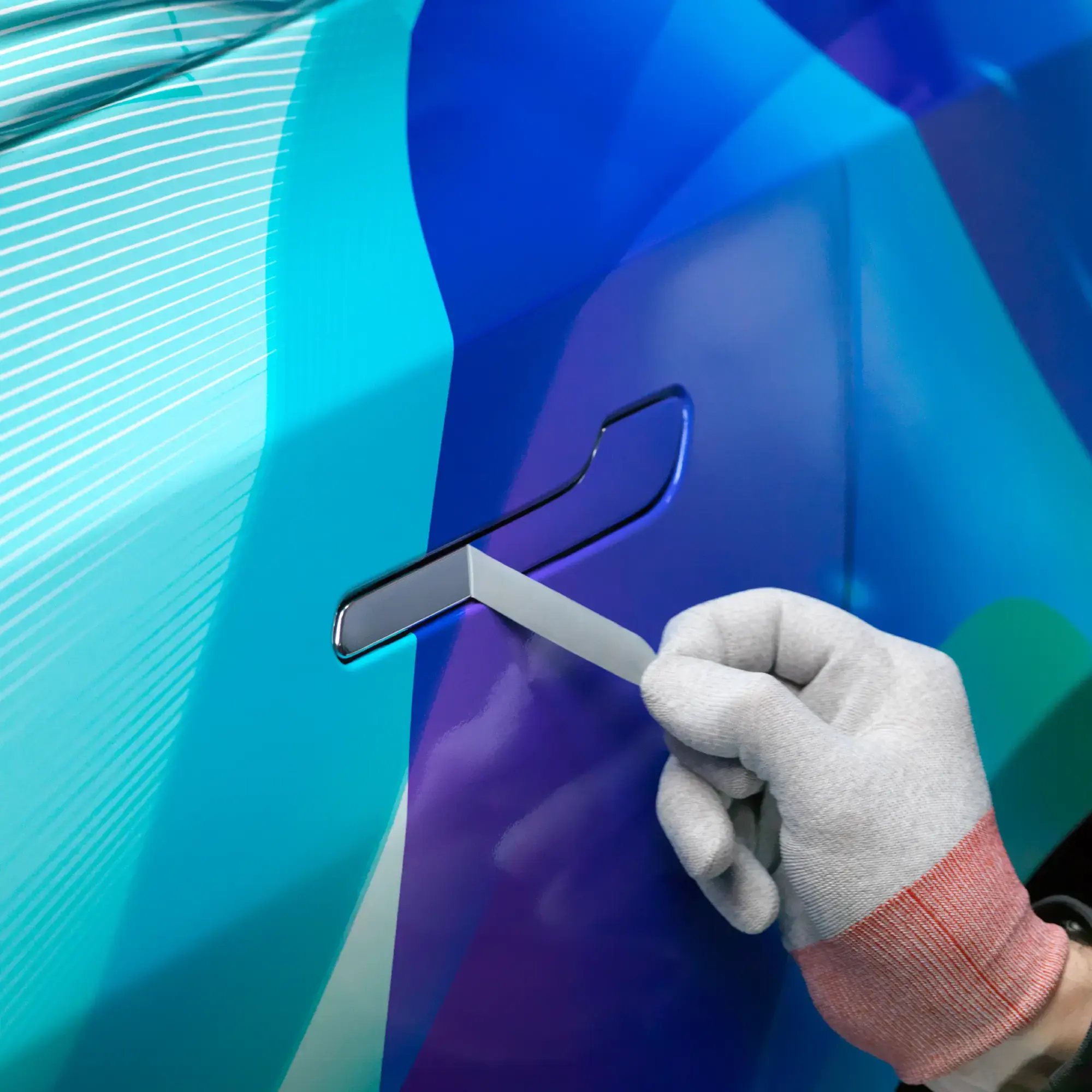 SL 6560 High Gloss PU, PVC-free, digital wrap laminate with SP 1504 print vinyl applied to the curved contours of this road car and a close-up of the fine detail as excess vinyl is expertly peeled away from the car door handle.