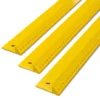 SOTT branded, yellow metal safety rulers for graphic arts, pictured at a 45 degree angle to show the safety "lip" to protect the fingers at the cutting edge of the rule and the measurements of the longest edge towards camera from the back to the front of the photo: 500mm, 1000mm and 1550mm rules.