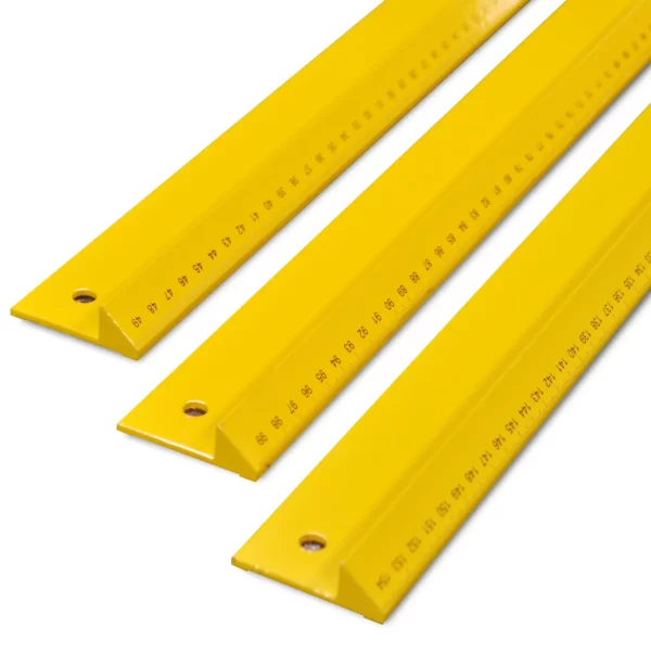 SOTT branded, yellow metal safety rulers for graphic arts, pictured at a 45 degree angle to show the safety "lip" to protect the fingers at the cutting edge of the rule and the measurements of the longest edge towards camera from the back to the front of the photo: 500mm, 1000mm and 1550mm rules.