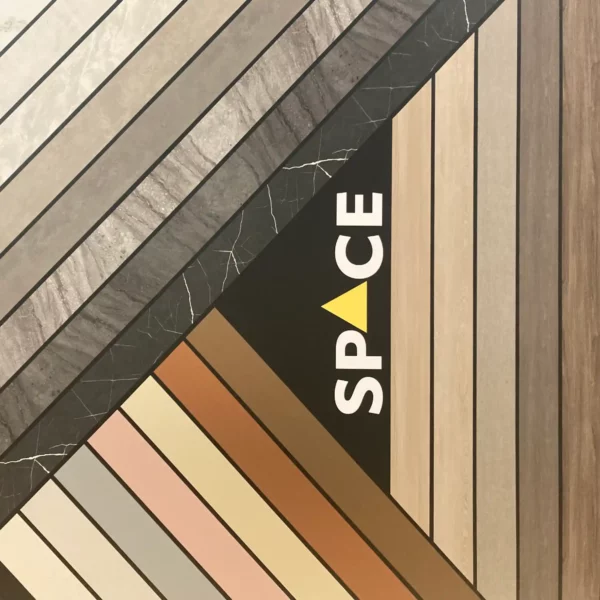 The decorative wall in the SPACE Interior Films training and demo area at All Print Supplies in Slough uses a small selection of self-adhesive interior films from the range of LX Hausys interior films to attractively showcase a few product choices with this wall display, including dark and light marble patterns, solid textured colours, woodgrain, leather, painted wood and more. Strips of dfferent films have been applied at 45 degree and 90 degree angles to each other rather like modern media centres, with a black vinyl background to accentuate out all the different complimentary colours and textures used.