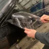 Stretching a gloss clear paint protection film over a car wing mirror to provide a very effective layer of additional protection to the paintwork.