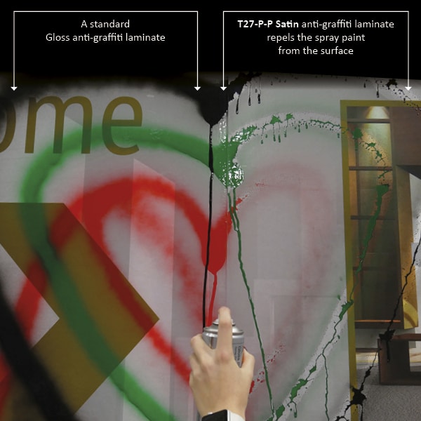 Graffiti spray paint is being sprayed onto a sign hoarding showing the difference between the left and right of the image where the standard gloss laminate on the left of the photo is leaving the graffiti on the surface, but on the right hand side T27-P-P is actually repelling the paint from the surface resulting a non-descript mess with no noticable image or 'tag' - the ink does not adhere and can be easily wiped from the surface.