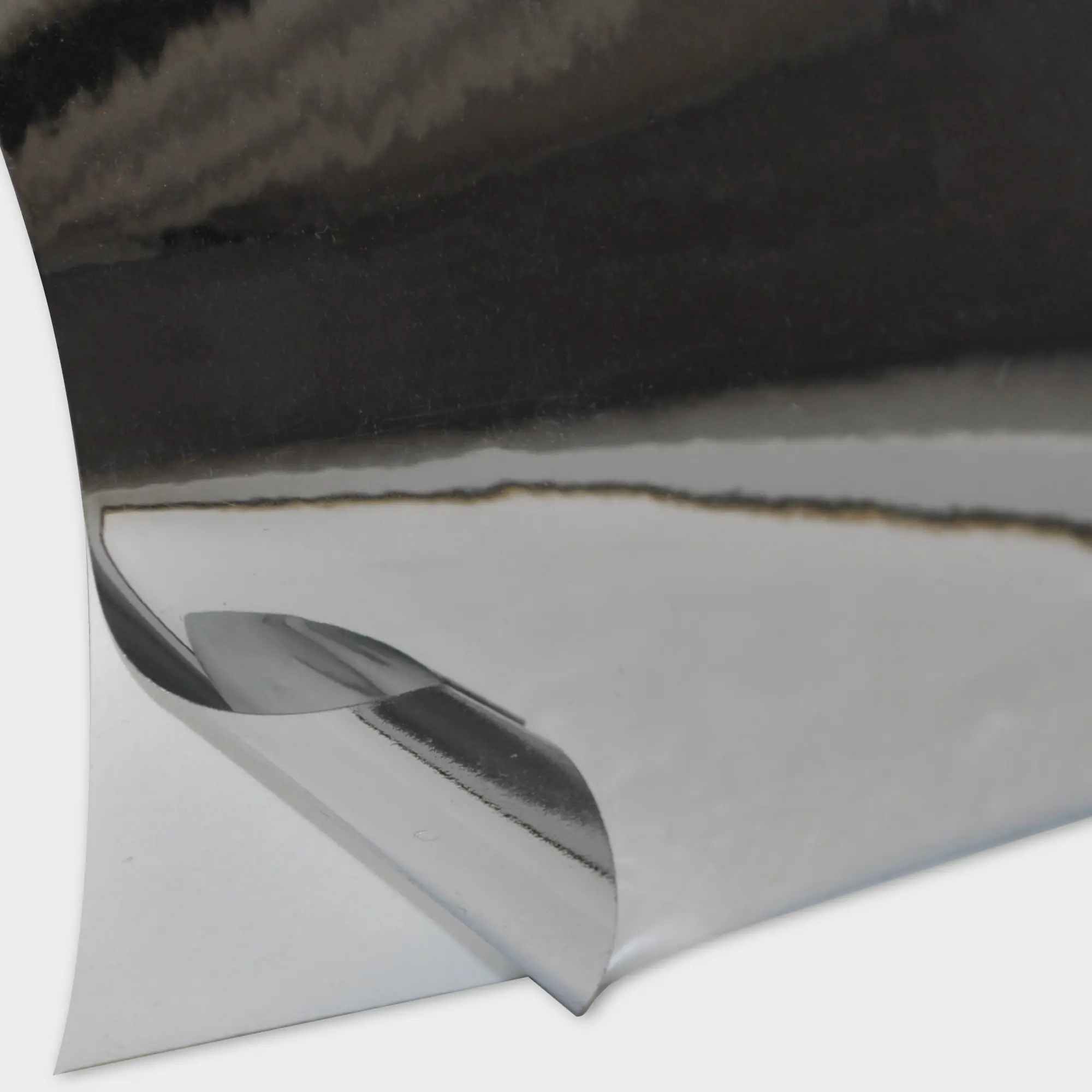 T60-P Bright Two-Way Silver vinyl with the self-adhesive metallised face film pulled back to reveal the cariier-liner behind and revealing both sides of the film which look identical on the face and back (adhesive side) showing how it can be used as a two-way viewable window film.