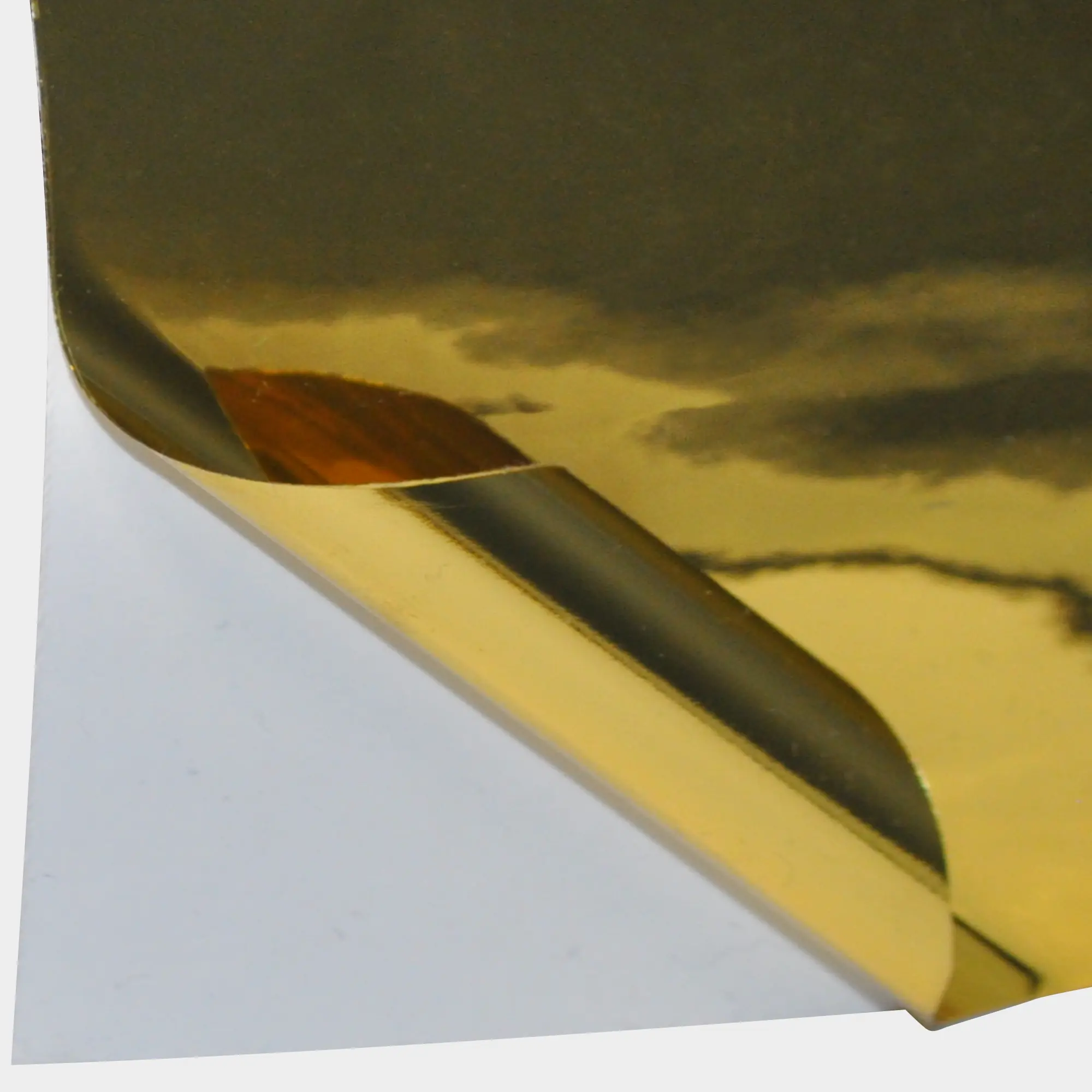 T60-P Bright Two-Way Gold graphics film with the self-adhesive metallised face film pulled back to reveal the release liner behind, revealing both sides of the film which look identical on the face and back (adhesive side) showing how it can be used as a true two-way viewable film on windows.