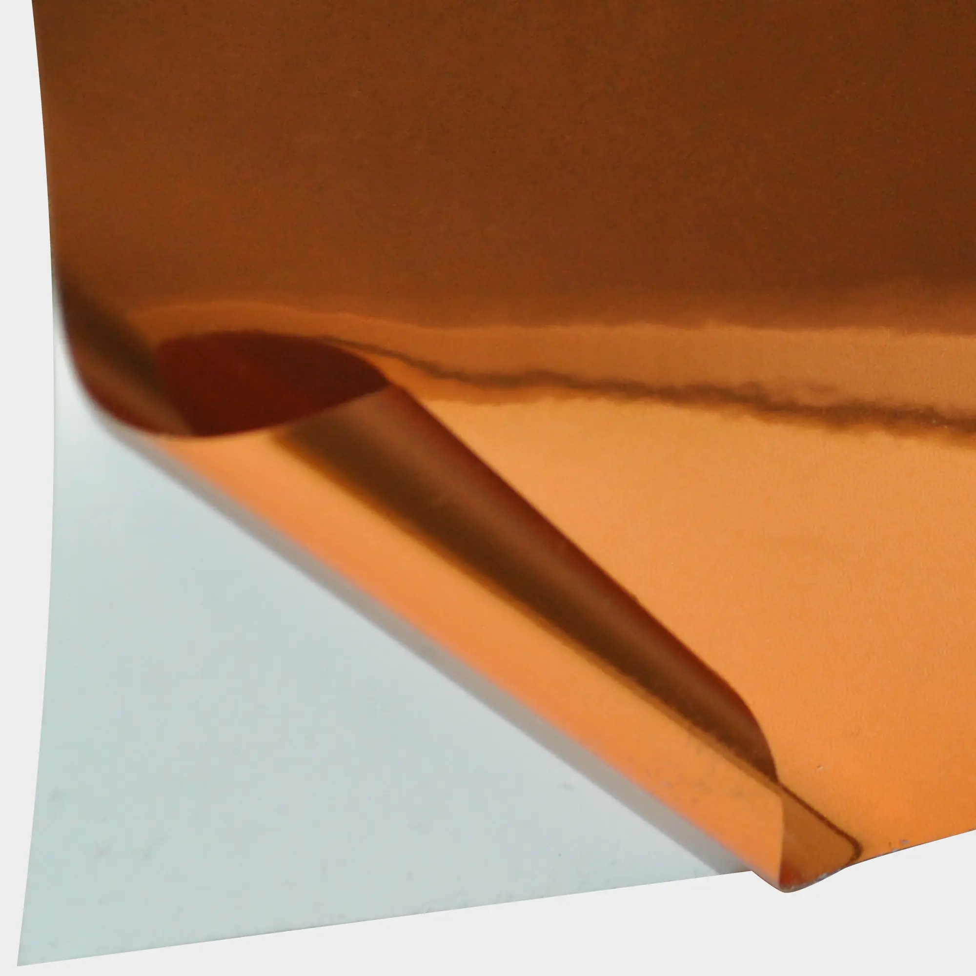 T74-P Bright Two-Way Copper metallised self-adhesive graphics vinyl with the face film peeled back to reveal the release-liner behind and showing both sides of the film that are identical on the face and on the reverse/adhesive side, so it can be used as a window film that is viewable from both sides of the glass.