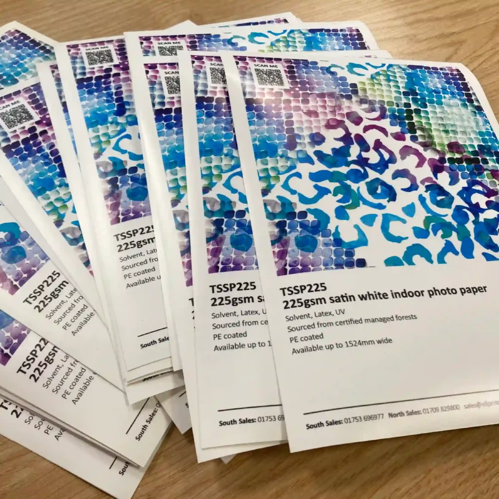 DigiPRINT TSSP225 satin photo paper in a stacked pile of printed A5 size promotional leaflets / sample prints.