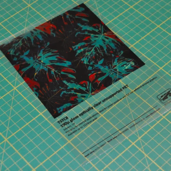 Sample of TSTC8 ultra-gloss clear backlit print film on a graphics cutting mat which clearly illustrates how this unsupported PET film offers exceptional clarity for premium illuminated displays.