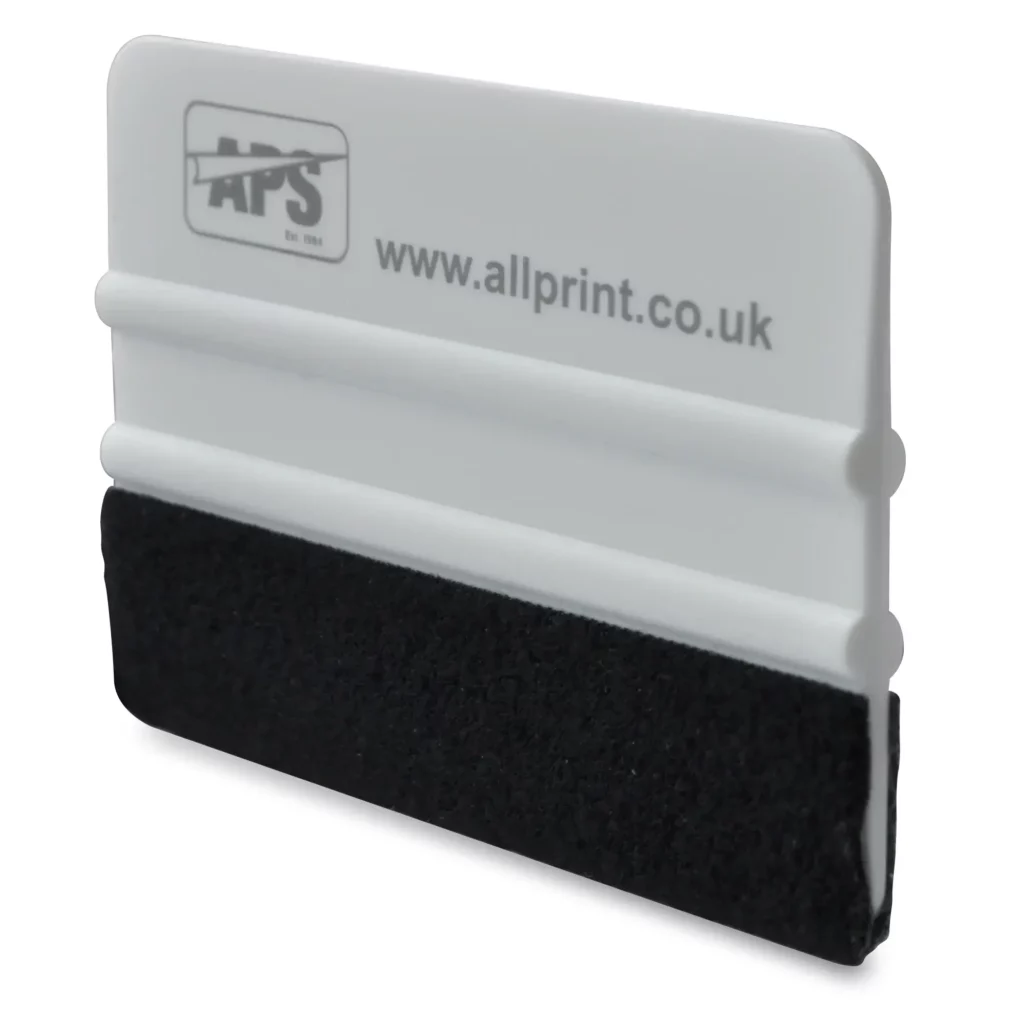 The perfect applicator for installing wrapping vinyls, 4 inch white ribbed plastic squeegee with a soft black felt covering over one edge, two central ribs for finger grip control and All Print Supplies branding on the side in black ink.